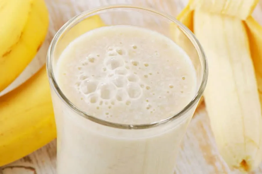 Szklanka mleka bananowego obok bananów