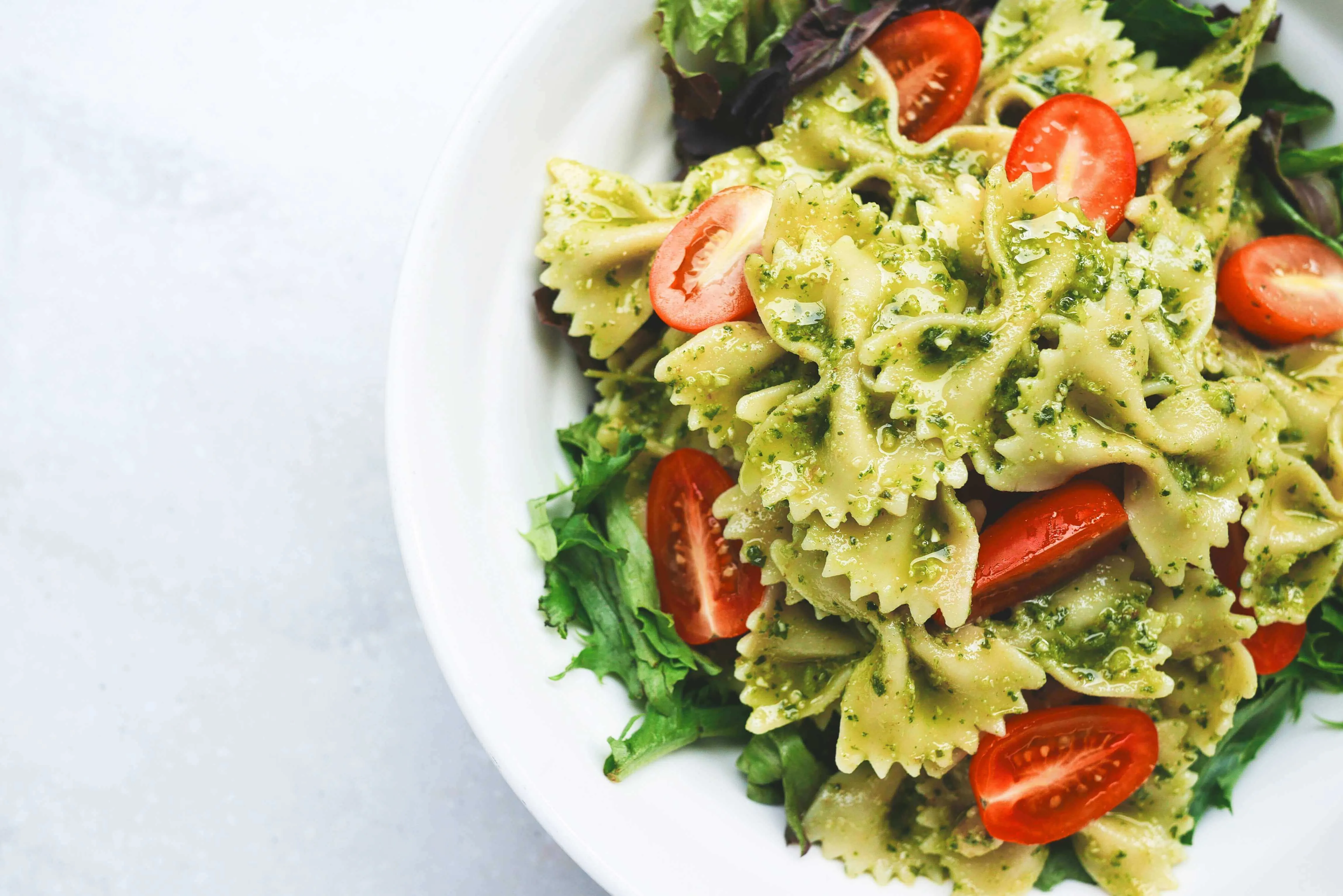 Makaron kokardki z zielonym pesto i pomidorkami koktajlowymi
